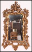A large 20th century rococo wall mirror having detailed gilt frame with crested top having inset