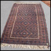A Persian handwoven rug having red ground with central medallions and chevron design having