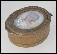 A 19th century Georgian brass oval pill box with lined interior having inset ivory / bone portrait