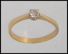 An 18ct gold ring set with central round cut solitaire diamond in a prong setting.