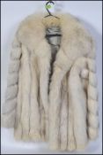 A ladies fox fur coat of a short length, likely around a size 18 and satin lined.