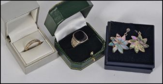 A silver gentlemans signet ring with a yellow and white metal eternity ring and a pair of ladies