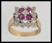 A 9ct gold ruby and diamond ladies dress ring, with four stones set to centre possibly rubies,