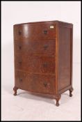 A 1930's Art Deco oak bow front chest of drawers raised on cabriole legs with pad feet having