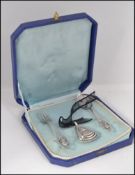A silver continental cased Christening set consisting of a babies rattle on lace with spoon and