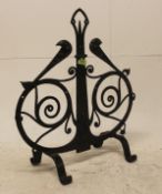 A 20th century Arts and Crafts wrought iron fire screen of scrolled form being ebonised and raised