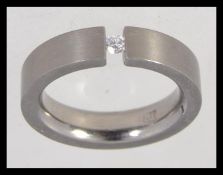 A titanium contemporary band ring with inset diamond single stone approx 5pnts. Weight 4.
