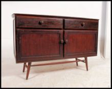 A retro 1970's Ercol style sideboard raised on an unusual clip on turned leg base.