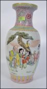 A large Chinese famille rose vase decorated with panel scenes of scholars and family scenes having
