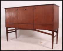 A 1970's retro teak wood Meredew Danish influence sideboard raised on tapered turned legs with