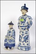 A large Chinese blue and white figurine of a scholar together with a smaller blue and white