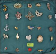 A collection of costume jewellery brooches all mounted onto a cushion,