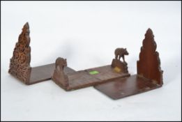 A pair of mid century Black Forest carved book trough / bookends in the form of Boars along with