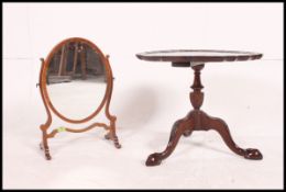 An Edwardian mahogany toilet swing mirror on scrolled base together with a pie crust occasional