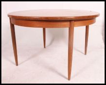 A 1970's G-Plan Fresco teak wood circular dining table raised on turned legs with extending table