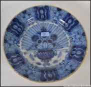 An 18th / 19th century Delft blue and white plate decorated with a spray of peacock feathers in a