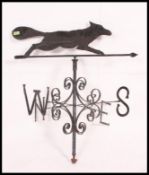 A large 20th century cast metal and ebonised weather vane with directional notation and fox above.