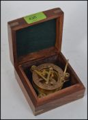 A small nautical sun dial and compass in brass, in brass inlaid hardwood hinged box.