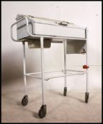 A vintage 20th century metal dentists - medical industrial cabinet being painted white with hinged