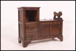 A Jacobean revival 20th century telephone table / hall settle having griffin carved end with hinged