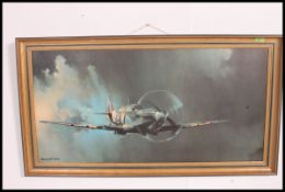 A large framed print of a spitfire in clouded sky being signed to the corner by Barrie Clark 100x50