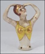 A 1930's Art Deco style pin dolly of ceramic form with lady dancing having pierced base