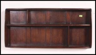 A 1970's Ercol plate rack having shelved centre with panel back in beech and elm ( see
