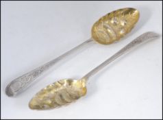 A pair of silver hallmarked berry spoons, chased handles with berry and fern bowls in relief.
