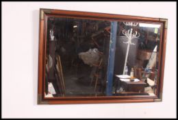 A 20th century contemporary mahogany and bras antique / campaign style beveled edge mirror.