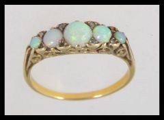 An early 20th century tested 9ct gold and opal ring set on a gypsy setting with plain shank having