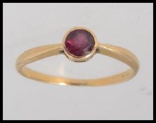 A 9ct yellow metal Art Deco style gold ring (tested to 9ct ) set with a central garnet stone in a