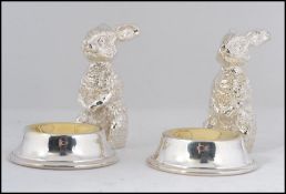 A wonderful pair of silver plated table salts in the form of seated rabbits with salt bowls to the