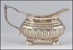 An Edwardian silver hallmarked rococo creamer on bun feet by Joseph Rodgers & Sons, Sheffield 1909.