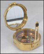 A brass cased compass and sundial set in a circular brass case with hinged cover,