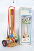 A retro 1980's croquet lawn set complete with boulle, within the original wheeled carrying holdall.