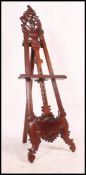 A 20th century mahogany rococo artists easel stand having folding hinges with stretcher and