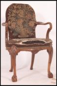 A 19th century mahogany open framed armchair being raised on claw and ball feet with cabriole legs