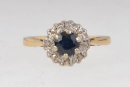 A hallmarked London 18ct gold sapphire and diamond ring having central round cut sapphire with