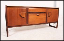 A vintage teak mid century sideboard beign raised on banded leg frames with two side cupboards,