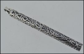 A 20th century ladies silver needle case of cylindrical form with cap, all in rococo form.