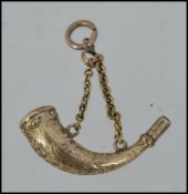 A gold unmarked gold fob watch winding key in the form of a hunting horn tests 9ct gold with hard