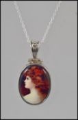 A ladies silver pendant necklace having inset enamel pictorial of a lady.