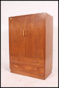 A 1930's Art Deco oak tallboy chest having twin cupboard doors with linen shelved interior over