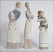 A collection of three Lladro porcelain figurines of young girls with animals,