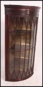 An Edwardian inlaid mahogany astragal glazed bow fronted corner cabinet having flared cornice with