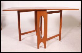 A retro 1970's teak wood drop leaf dining table having pierced supports,