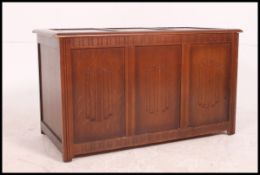 A mid century oak Jacobean revival coffer blanket box with inset panels and hinged top above
