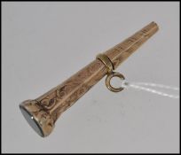 An unmarked gold fob watch winding key tests 9ct gold with hard stone end and etched decoration.
