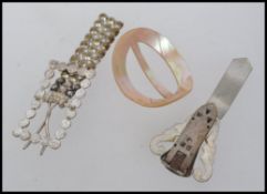 An early 20th century mother of pearl buckle together with a white metal paste set buckle and a