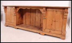A Victorian pine low dresser base comprising end cupboards with central open recess shelf finished